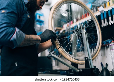 Young beard bicycle mechanic repairing bicycles in a workshop.	 - Powered by Shutterstock