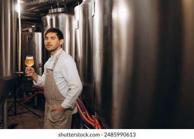 young bearded attractive male brewer with wooden beer mug in hand on background of brewery - Powered by Shutterstock