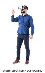 Young bearded business man wearing virtual reality using finger on augmented reality touch screen. Full body isolated on white background.