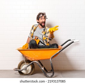 young bearded construction worker man on a wheelbarrow - Powered by Shutterstock