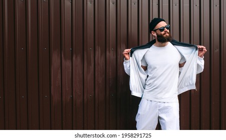 Young Bearded Hipster Guy Wearing A Vintage Tracksuit And White Blank T-shirt. Mock-up For Print. T-shirt Template.