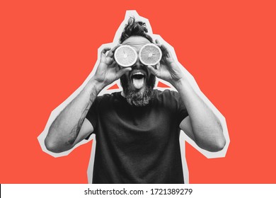 Young bearded hipster man holding slices of orange in front of his eyes. Crazy emotions