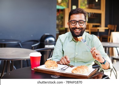 Young Bearded Indian Man Eating In A Cafe