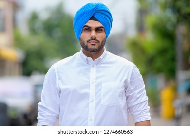 Young bearded Indian Sikh man wearing turban outdoors