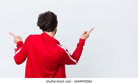 Young Bearded Man Back View Smiling, Feeling Carefree, Relaxed And Happy, Dancing And Listening To Music, Having Fun At A Party Against Copy Space Wall