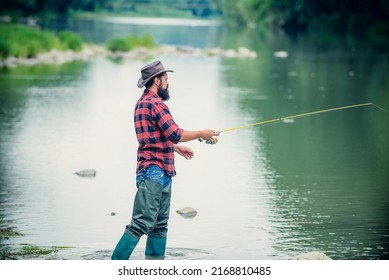 Young Bearded Man Fishing At A Lake Or River. Flyfishing.