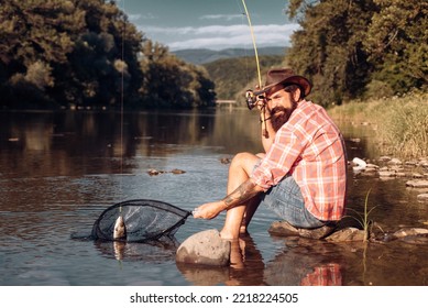 Young Bearded Man Fishing At A Lake Or River. Flyfishing.