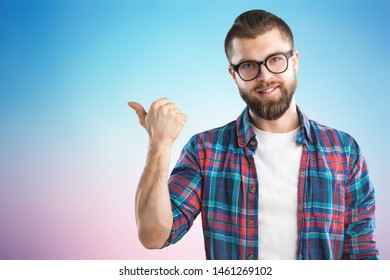 Young bearded man with glasses points back