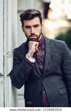 Guy with beard and modern hairstyle in the street.