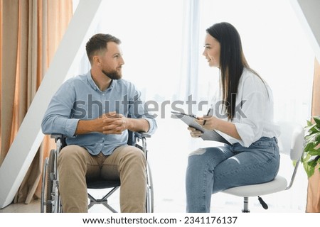Young bearded man on wheelchair during home psychotherapy.