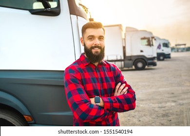 Young bearded man standing in front of his truck.