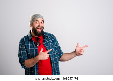 Young Bearded Man Is Surprised And Pointing To The Side