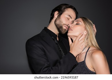 Young Bearded Man Touching Sexy Blonde Girlfriend On Grey Background