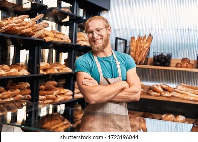 Young bearded man wearing eyeglasses and apron assistant standing at bakery shop small business crossed arms looking aside smiling cheerful - Powered by Shutterstock