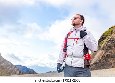 Young Bearded Man Wearing White Puff Jacket Standing Near A Mountain