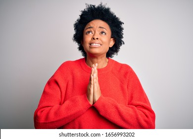 Young Beautiful African American Afro Woman With Curly Hair Wearing Red Casual Sweater Begging And Praying With Hands Together With Hope Expression On Face Very Emotional And Worried. Begging.