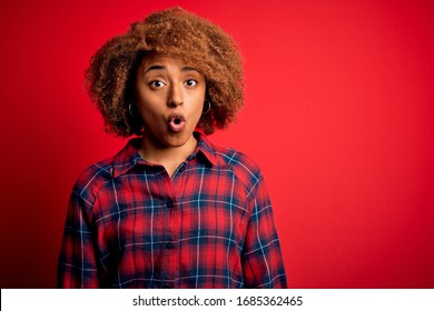 Young Beautiful African American Afro Woman With Curly Hair Wearing Casual Shirt Afraid And Shocked With Surprise Expression, Fear And Excited Face.