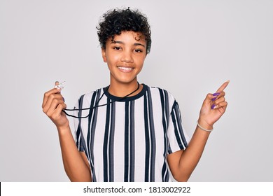 Young Beautiful African American Afro Referee Woman Wearing Striped Uniform Using Whistle Very Happy Pointing With Hand And Finger To The Side