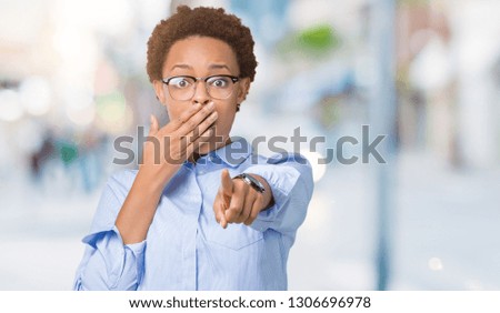 Young beautiful african american business woman over isolated background Laughing of you, pointing to the camera with finger hand over mouth, shame expression