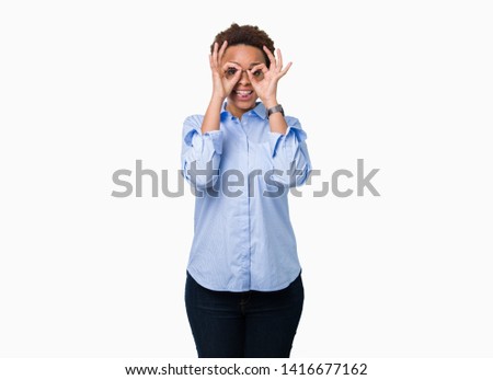 Young beautiful african american business woman over isolated background doing ok gesture like binoculars sticking tongue out, eyes looking through fingers. Crazy expression.