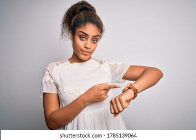 Young beautiful african american girl wearing casual t-shirt standing over white background In hurry pointing to watch time, impatience, upset and angry for deadline delay