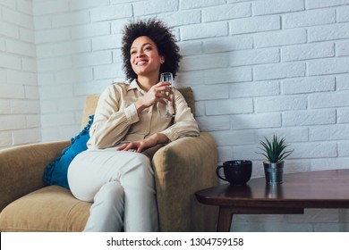 Young Beautiful African American Woman Relaxing At Home, Drinking Wine.