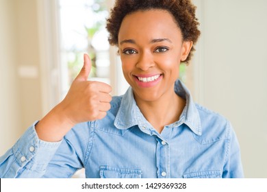 Young beautiful african american woman doing happy thumbs up gesture with hand. Approving expression looking at the camera with showing success. - Shutterstock ID 1429369328