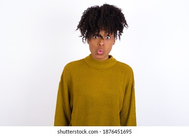 Young beautiful African American woman wearing knitted sweater against white wall,  expressing disgust, unwillingness, disregard having tensive look frowning face, looking indignant with something. - Shutterstock ID 1876451695