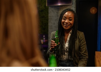 Young Beautiful African American Woman Drinking Beer In The Bar With Her Colleagues After Work