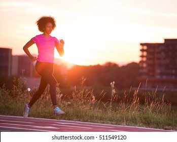 Young Beautiful African American Woman Enjoys Running Outside Beautiful Summer Evening In The City