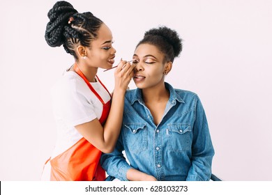 Young Beautiful African American Woman Applying Make-up By Make-up Artist