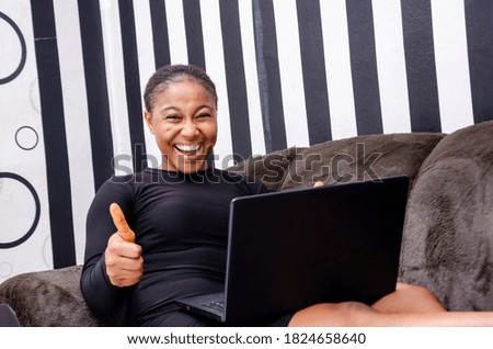 young beautiful african lady feeling excited about what she saw on her laptop