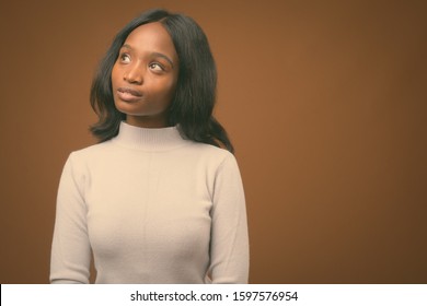 Young beautiful African Zulu businesswoman against brown background - Shutterstock ID 1597576954