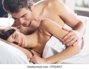 Young beautiful amorous couple making love in bed