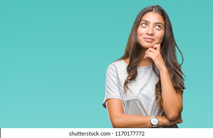 Young Beautiful Arab Woman Over Isolated Background With Hand On Chin Thinking About Question, Pensive Expression. Smiling With Thoughtful Face. Doubt Concept.