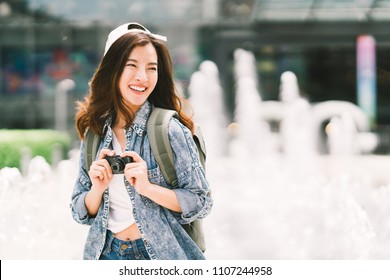 Young Beautiful Asian Backpack Traveler Woman Using Digital Compact Camera And Smile, Looking At Copy Space. Journey Trip Lifestyle, World Travel Explorer Or Asia Summer Tourism Concept