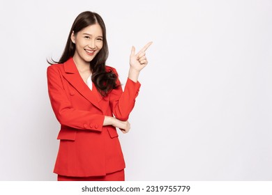 Young beautiful Asian businesswoman in red suit smiling and pointing to empty copy space isolated on white background - Shutterstock ID 2319755779