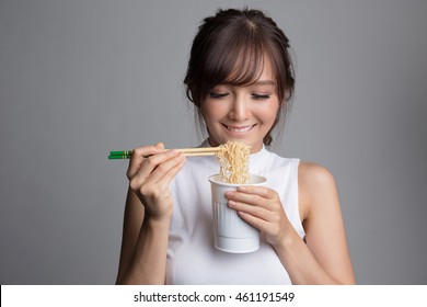 Young Beautiful Asian Girl Eating Instant Noodle Using Chopsticks.