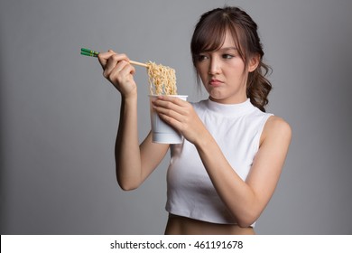 Young Beautiful Asian Girl Eating Instant Noodle Using Chopsticks.