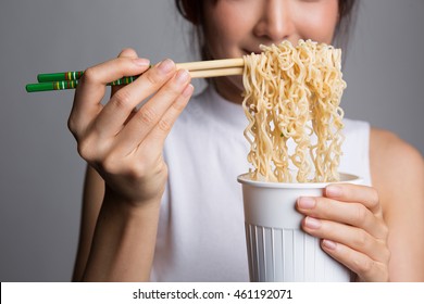 Young Beautiful Asian Girl Eating Instant Noodle Using Chopsticks.