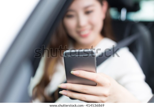 young beautiful\
asian girl with phone in\
car