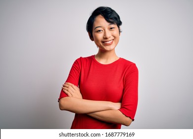 Young Beautiful Asian Girl Wearing Casual Red T-shirt Standing Over Isolated White Background Happy Face Smiling With Crossed Arms Looking At The Camera. Positive Person.