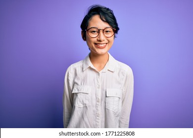 Young Beautiful Asian Girl Wearing Casual Shirt And Glasses Standing Over Purple Background With A Happy And Cool Smile On Face. Lucky Person.