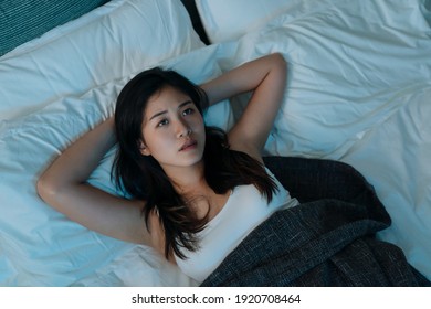 Young Beautiful Asian Korean Woman At Home Bedroom Lying In Bed Late At Night Trying To Sleep Suffer Insomnia Sleeping Disorder. Girl Scared On Nightmares Look Sad Worried In Mental Health Concept