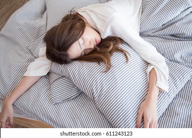 Young Beautiful Asian Lazy Woman Sleeping On The Bed In Vintage Cozy Bedroom At The Morning