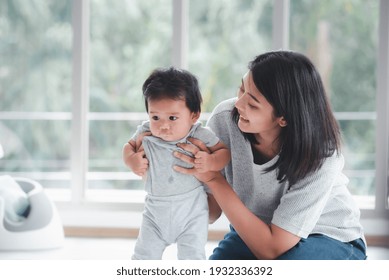 Young Beautiful Asian Mother Playing With Her Baby.