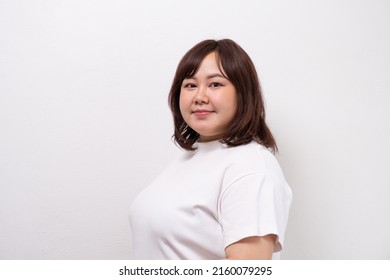 Young beautiful Asian oversize women smile with positive emotion, feeling happy and proud with her body size. Portrait shot on white background with copy space. - Shutterstock ID 2160079295