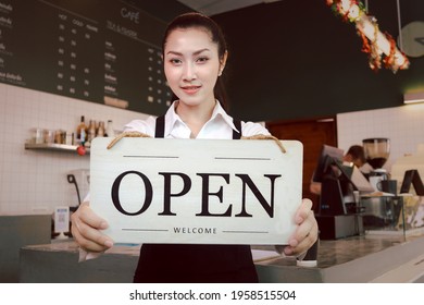 Young Beautiful Asian Woman Barista Holding Open Sign Broad At Restaurant And Coffee Shop For Telling Customers That Shop Is Ready To Service.