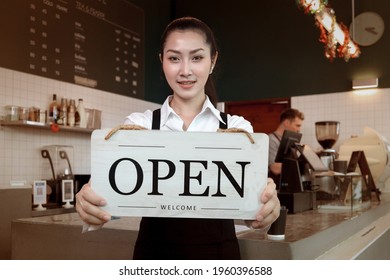 Young Beautiful Asian Woman Barista Holding Open Sign Broad At Restaurant And Coffee Shop For Telling Customers That Shop Is Ready To Service.