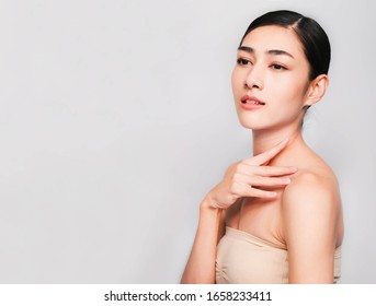young beautiful asian woman with clean and bright skin, Cosmetic Beauty Concept,hands touch on the cheek, smiling and friendly face isolated on grey background - Shutterstock ID 1658233411